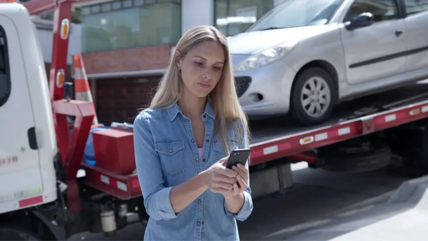 Mujer esperando la grúa con su teléfono